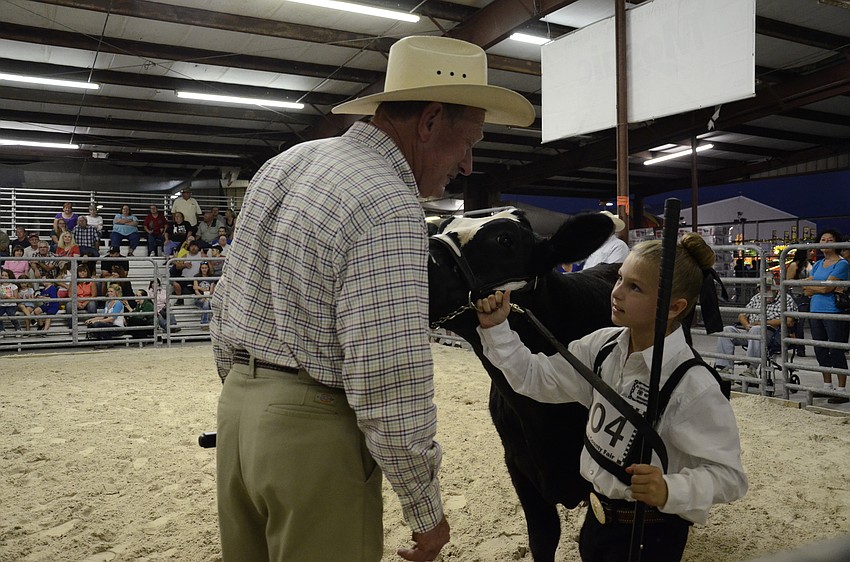 Judge Andy Andreasen talks with Katelyn Sanders, Jr. Cattlemen Club, about her heifer.