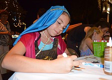 Dressed in a costume she put together, 10-year-old Alyssa Trompke, of Bradenton, colors a Christmas craft.