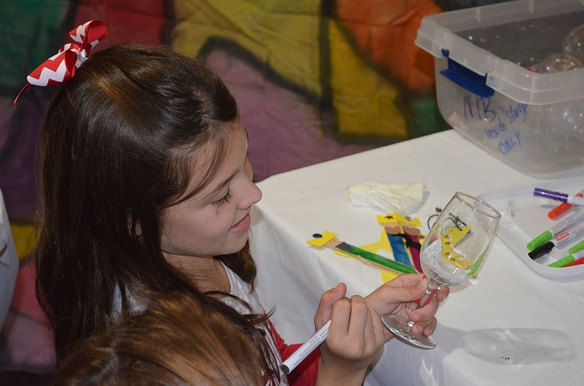 Lily Edwards, of Bradenton, puts the final touches on a glass she's decorating.