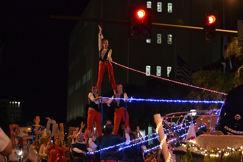 Performers from Sarasota Ski-A-Rees Water Ski Show Team Naddie Ashbury, Jenn Guttieri and Becca Root tower over parade goers.