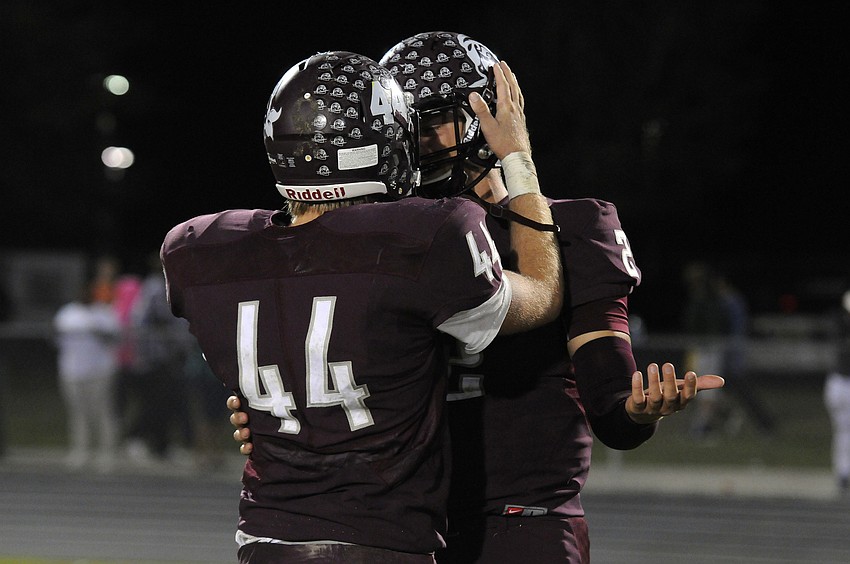Junior linebacker Matthew Haftke hugs Braden River senior quarterback Jacob Huesman following the Pirates Class 7A state semifinal loss to St. Thomas Aquinas Dec. 4.