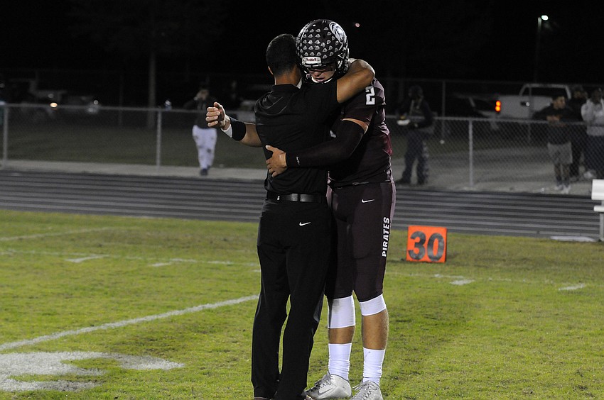 Braden River coach Curt Bradley consoles senior quarterback Jacob Huesman following the Pirates Class 7A state semifinal loss to St. Thomas Aquinas Dec. 4.