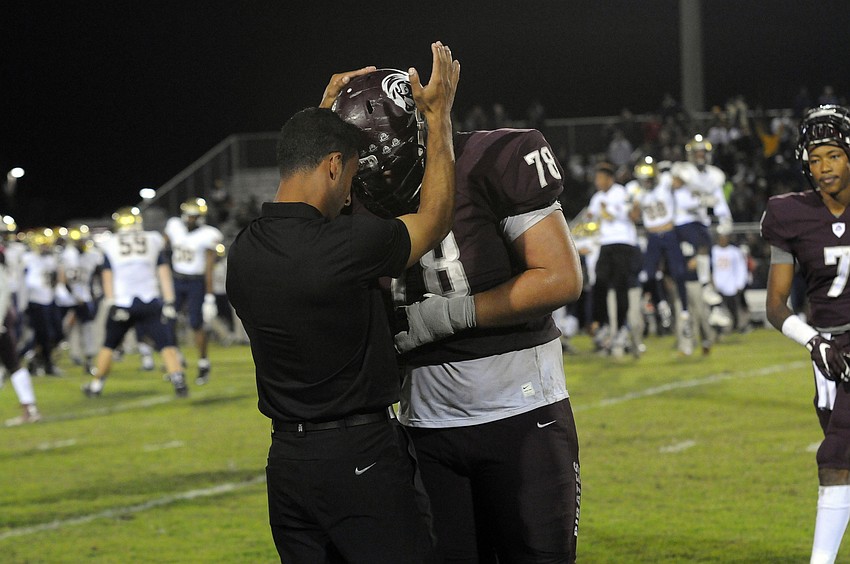 Braden River coach Curt Bradley talks with senior lineman Alex Salguero following the Pirates Class 7A state semifinal loss to St. Thomas Aquinas Dec. 4.