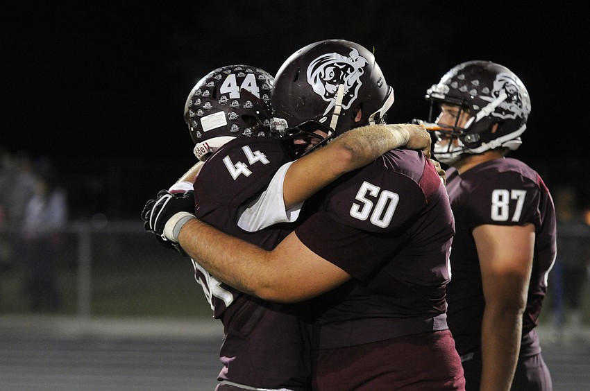 Braden River junior linebacker Matthew Haftke and senior defensive lineman Michael Walker console each other following the Pirates Class 7A state semifinal loss to St. Thomas Aquinas Dec. 4.
