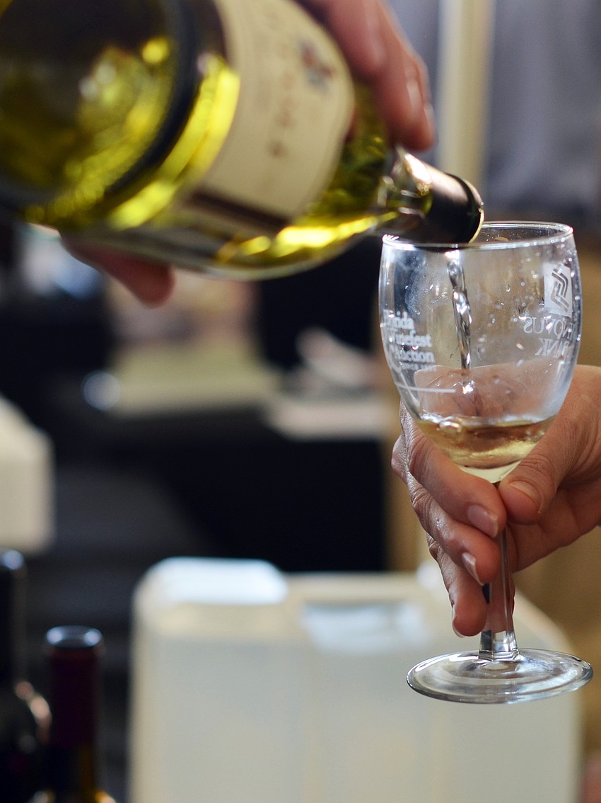 A guest tastes a wine sample from Christopher Creek Winery at the Florida Winefest and Auction Bayfront Showcase Lunch Tasting.