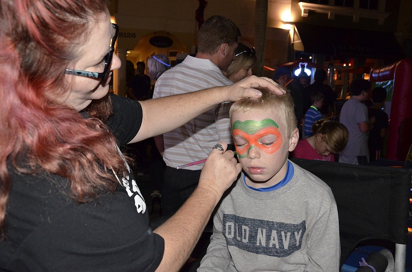 Tiffany David with Childlike Productions paints the face of Cameron Locke of Lakewood Ranch.