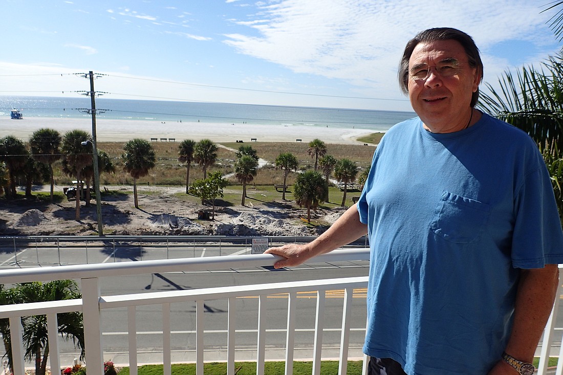 Paul Parr, on the balcony of his unit at Sunset Royale, overlooking the west end of Siesta Key Public Beach.