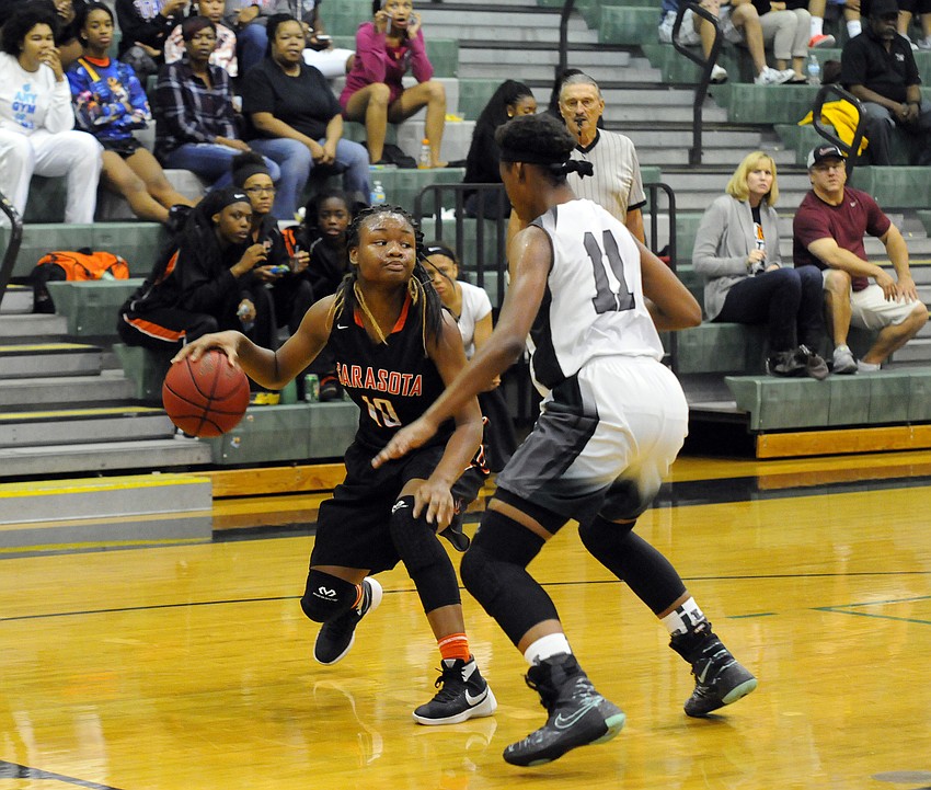 Sarasota sophomore Imani Jones looks to dribble around Lakewood Ranch's India Searls.