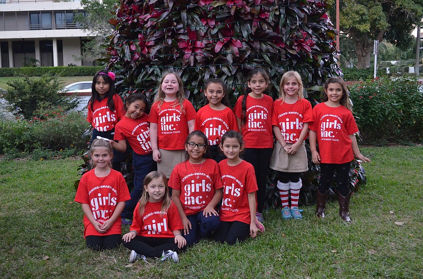 The students from Girls Inc. of Sarasota County pose in front of the bromeliad tree.