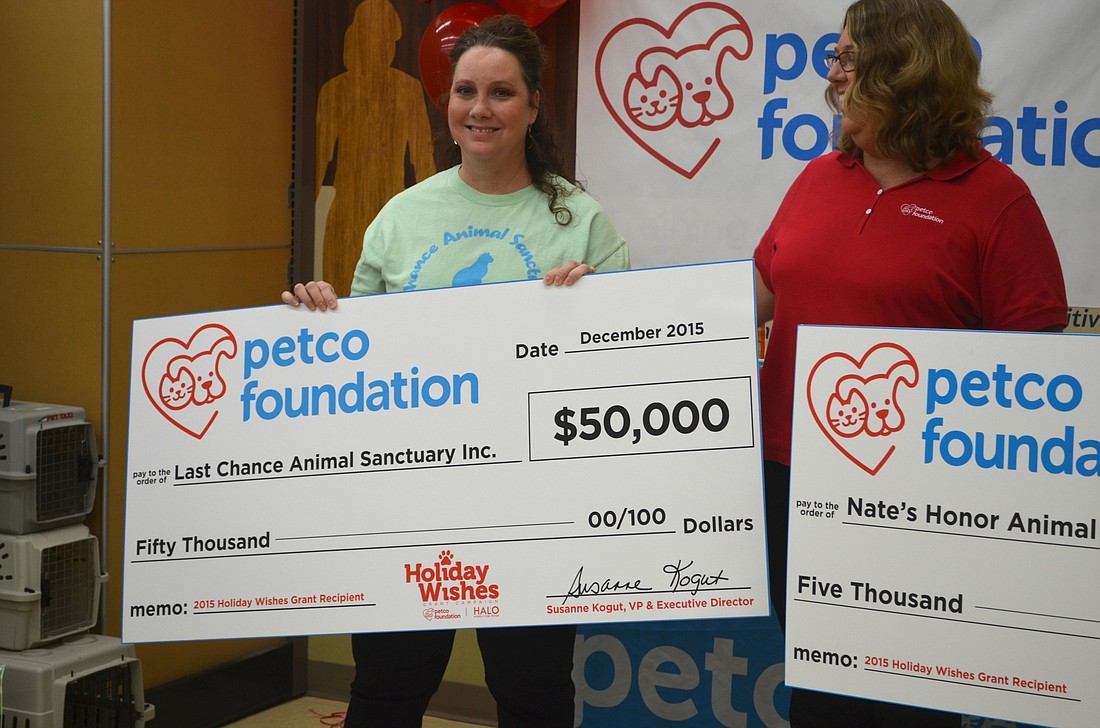 Carrie Mann accepts a $50,000 check on behalf of Last Chance Animal Sanctuary Inc.
