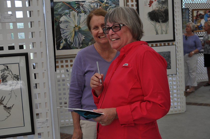 University Park residents Cheryl Frandsen and Leah Cook decide on their “People’s Choice” votes.