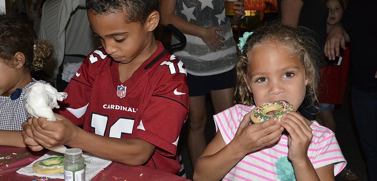 Lakewood Ranch kids Devin Raines, left, finishes up his cookie while Alexa Thornton, right, takes a bite. "It's good!" she said.