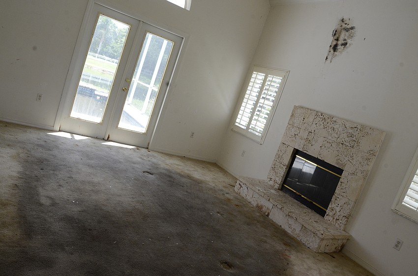 BEFORE: The carpet was stained in the living room from a roof leak, and mold speckled the wall.