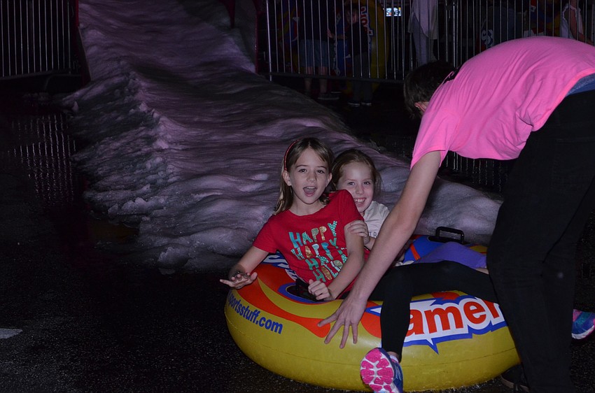 Reagan Hughes and Julia Perkins enjoy a turn down the ice slide.