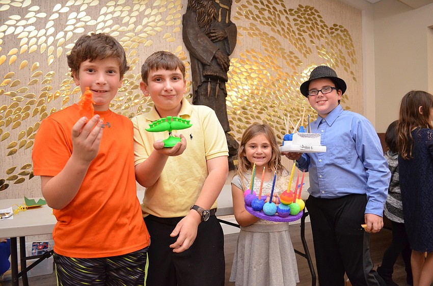 Sam and David Howard with Dani Mallitt and Garret Pearson and their menorahs.