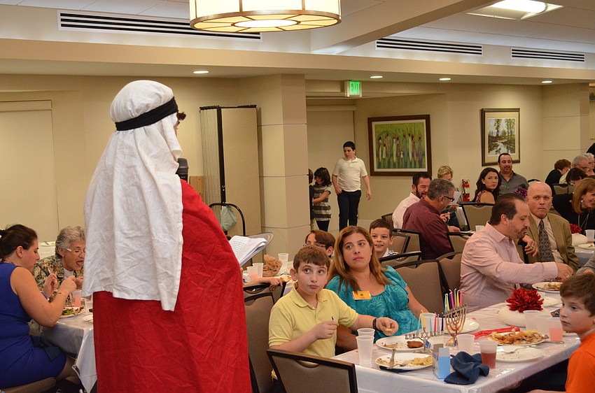 Moses Glickman dressed as Judas Maccabee tells the story about the miracle oil that kept the lantern burning for eight nights.