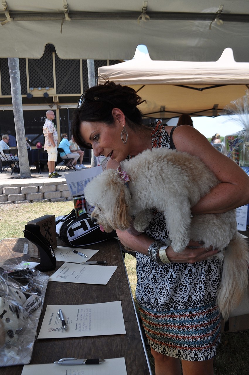 Michelle Senglaub and her dog, Lily, check out auction items.
