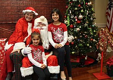 Jeanne and John Larranaga, or Mrs. Claus and Santa, pose with Hannah and Haven Wood.