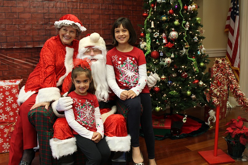 Jeanne and John Larranaga, or Mrs. Claus and Santa, pose with Hannah and Haven Wood.