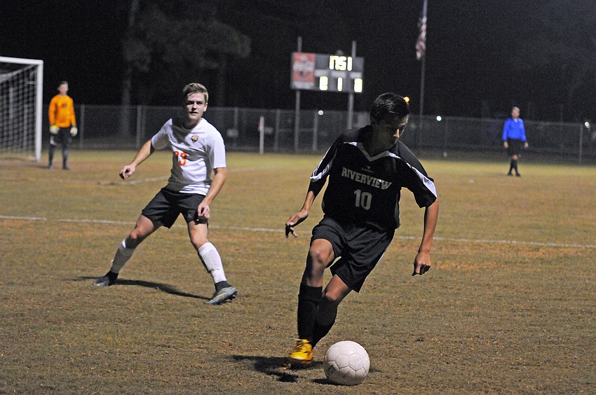 Riverview senior midfielder Felipe Rojas dribbles the ball around the field.