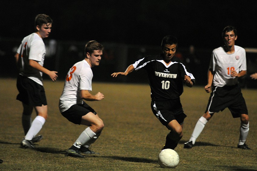 Riverview senior midfielder Felipe Rojas attempts to maneuver the ball around Sarasota's line of defense.