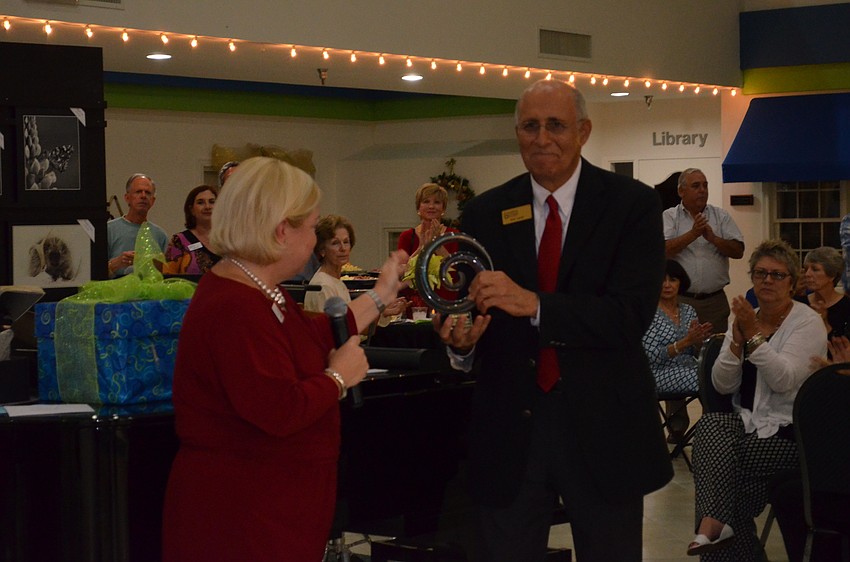 Erin McLeod presents Bob Carter with a sculpture to commemorate his 28 years of leadership at the Friendship Centers.