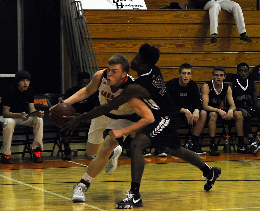 Sarasota's Zach Rowden attempts to drive past Braden River's Jamal Owens.
