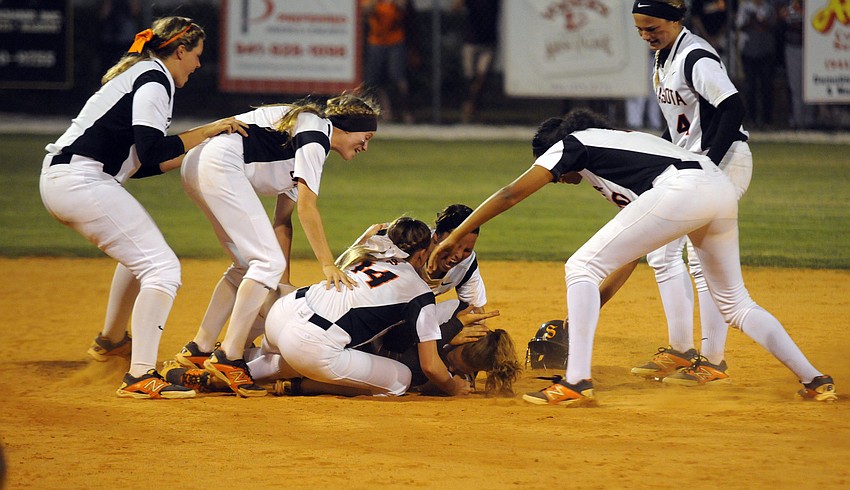 Third baseman SarahBeth Wengerd is mobbed by her teammates after hitting a 2-run walk-off double in the Class 7A-District 10 championship April 16.