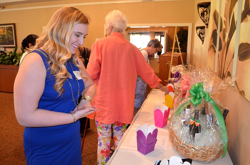 Heather Cissel browses the raffle items available, such as wine, cake decorating kits and classes, and paintings.