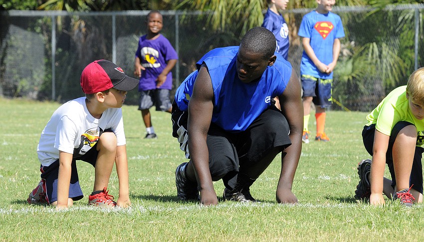 Six-year-old Aiden Lorman receives some last minute advice from Riverview defensive tackle Malik Wesley before the 40-yard dash during the Rams' annual summer football camp July 7 through July 9.