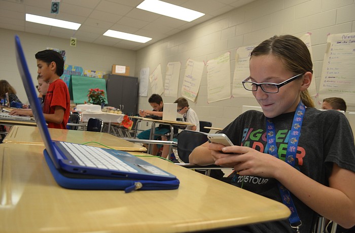 Kayla Morris uses her iPhone and laptop during class at Nolan Middle.