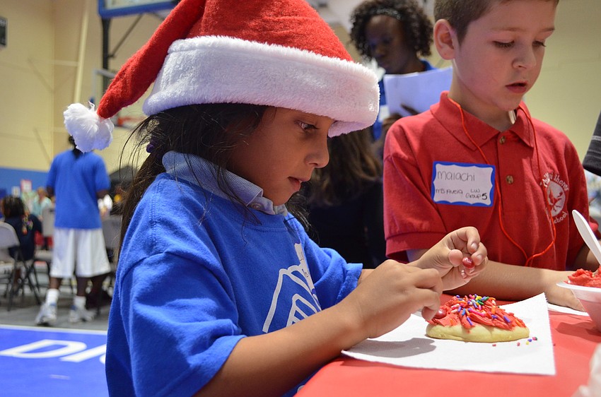 Luna Valle focuses on decorated her sugar cookie with icing.