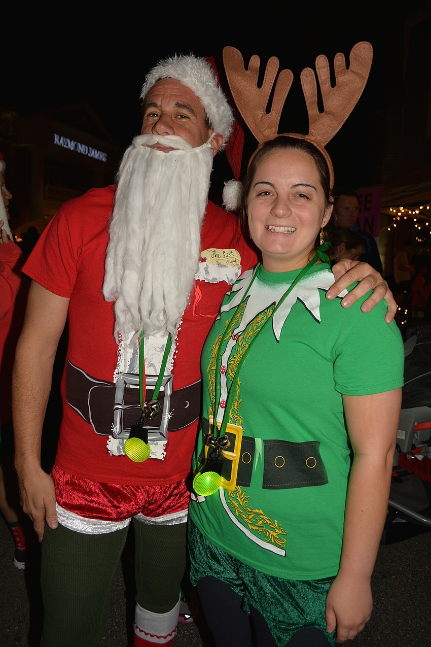 Santa, Andrew Spiegel, runs alongside his reindeer, Allison Sutton.