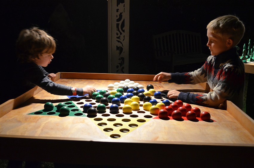 Magness Rollins and Max Ruzek master the game of Chinese checkers.