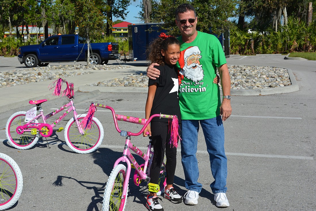 Amari Sielaff gets a hug from Tim Hyden after she picks out a bicycle.