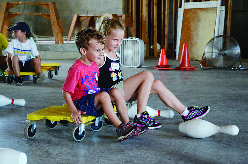 Evan Branson and Madison McCaffery race to knock over a pin at Risen Savior Lutheran Church’s Vacation Bible School.