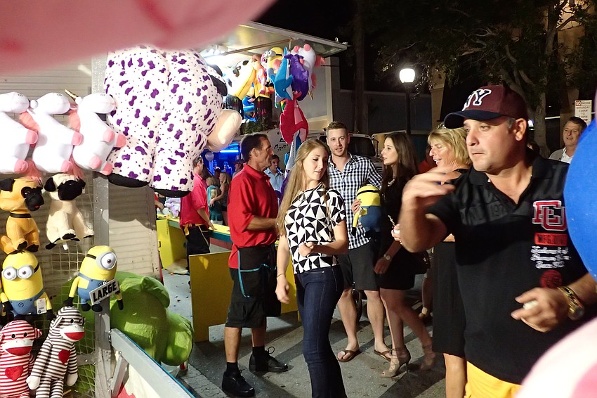 Ariel Gil (right) tries for a prize, while Ana Ennos (left) looks on.