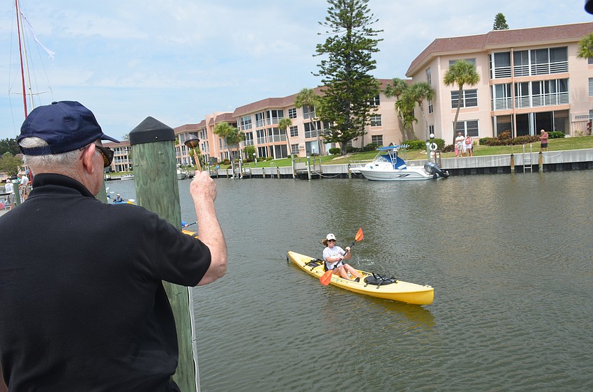 Msgr. Gerry Finegan blesses Barbara Bellamente’s kayak.