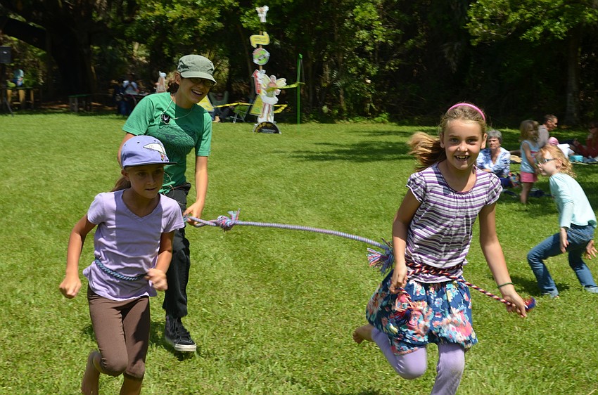 Dylyn Kelly, Paige Green and Hailey Hoag play in the field of the butterfly garden at Historic Spanish Point.