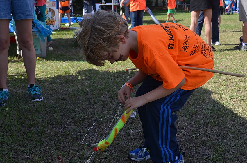 Thomas McLaughlin gets a stuffed animal snake from the fishing booth.