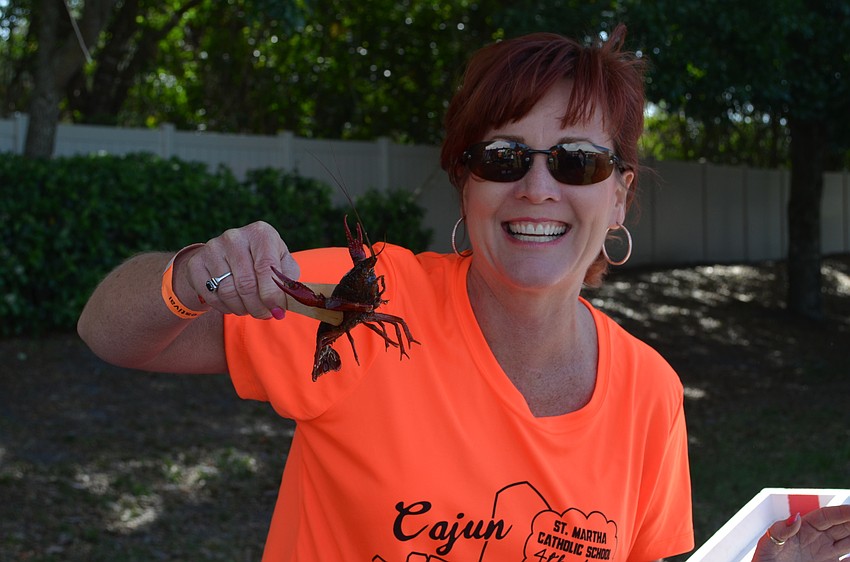 Wendy Johnson holds up one of the crawfish competing in the crawfish races.