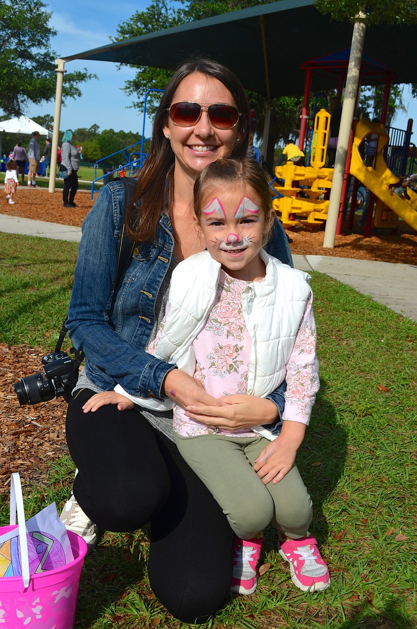 Angie Crutchfield and her daughter, Addison, head toward the backfield to gather Easter eggs.