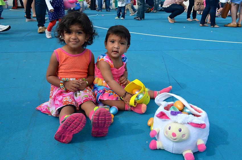 Sisters Aaniya and Aaliya Mittal ejoy the fruits of their egg-hunting labor.