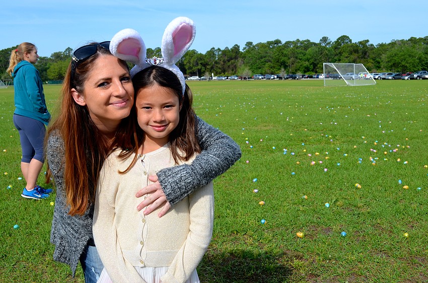 Jen Strickland and her daughter, Viviannah, find a spot in the crowd to prepare for the egg hunt.