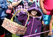 Natalie Merino shades her face from the sun, but not her empty basket; she’s ready to hunt eggs, she said.