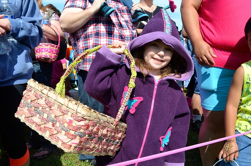 Natalie Merino shades her face from the sun, but not her empty basket; she’s ready to hunt eggs, she said.
