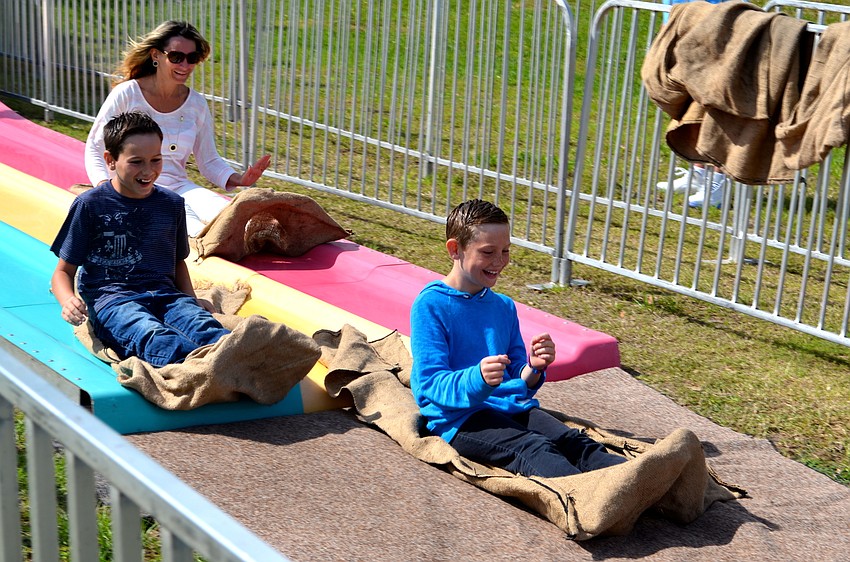 Alex and Troy Doyle whip down the giant slide, with their mother, Gail, close behind them.