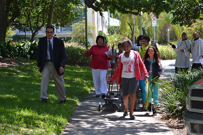 Brianna Waters leads the palm procession tugging Domingo Ramos the donkey at Church of the Redeemer