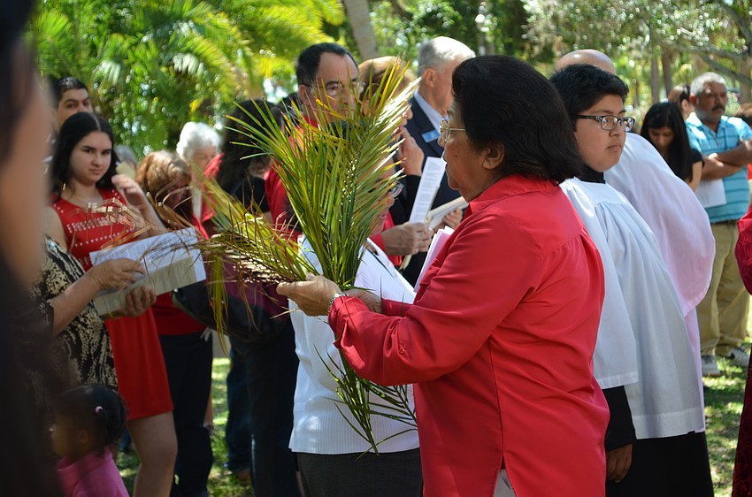 Maria Elena Benavides passes out palm fronds to members.