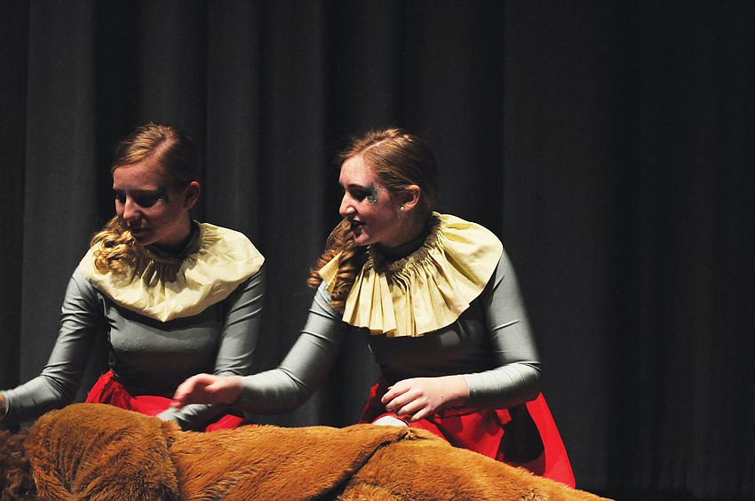 Sydney Avery and Meg Phillips blow their poppy dust over the Lion.